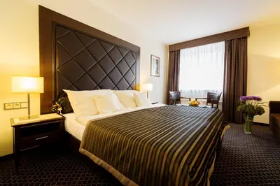 a hotel room with a large bed and a window at Hotel Selsky Dvur - Bohemian Village Courtyard in Prague