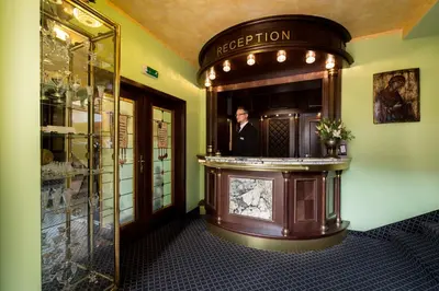 a man is standing in a mirror in a room at Hotel Selsky Dvur - Bohemian Village Courtyard in Prague