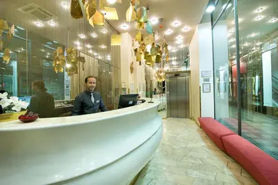 a man sitting at a counter in a lobby at EA Hotel Rokoko in Prague