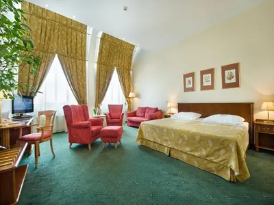 a hotel room with a bed and a desk and chairs at EA Hotel Rokoko in Prague