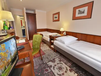 a hotel room with two beds and a flat screen tv at EA Hotel Jeleni Dvur Prague Castle in Prague