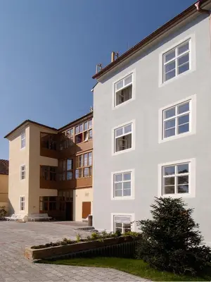 a white building with two buildings in the background at EA Hotel Jeleni Dvur Prague Castle in Prague