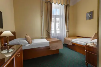 a hotel room with two beds and a window at Hotel William in Prague