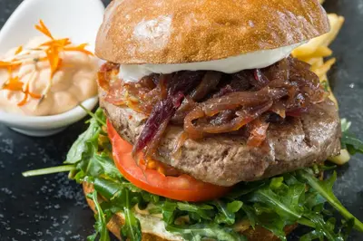 a sandwich with bacon and lettuce and a tomato at Grandium Hotel Prague in Prague