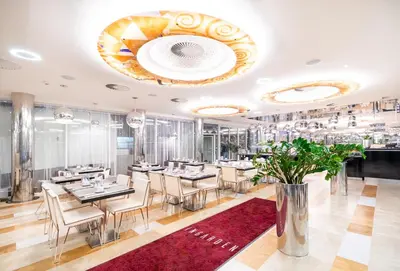 a restaurant with tables and chairs and a red rug at Grandium Hotel Prague in Prague