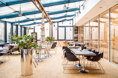 a restaurant with tables and chairs and windows at Grandium Hotel Prague in Prague