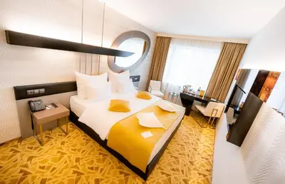 a hotel room with a large bed and a desk at Grandium Hotel Prague in Prague