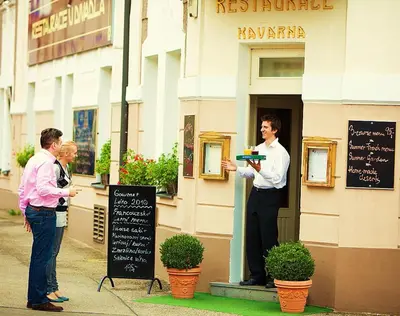 two men are standing outside of a restaurant at Hotel U Divadla - Czech Leading Hotels in Prague