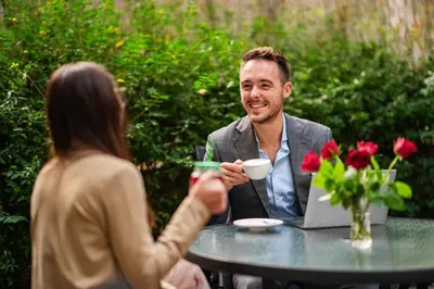 a man and a woman sitting at a table with a cup of coffee at Hotel U Divadla - Czech Leading Hotels in Prague