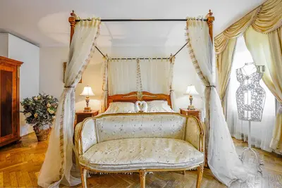 a bedroom with a canopy bed and a chair at Boutique Hotel Green Lobster in Prague