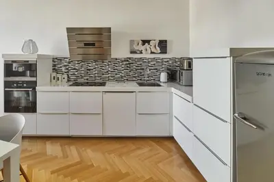 a kitchen with a white table and white chairs at Prague Days - Apartment with Balcony and Amazing View in the Old Town in Prague