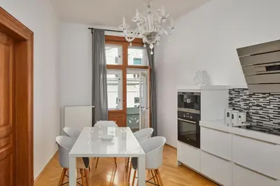 a bedroom with a bed and a table and a chair at Prague Days - Apartment with Balcony and Amazing View in the Old Town in Prague