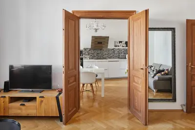 a white kitchen with white appliances and wooden floors at Prague Days - Apartment with Balcony and Amazing View in the Old Town in Prague
