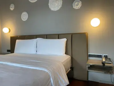 a bedroom with a bed with two pillows and a phone at 987 Design Prague Hotel in Prague