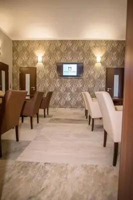 a waiting room with chairs and a tv on a wall at Hotel City Bell in Prague
