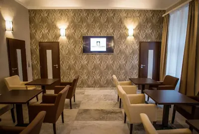 a restaurant with tables and chairs and a tv on a wall at Hotel City Bell in Prague