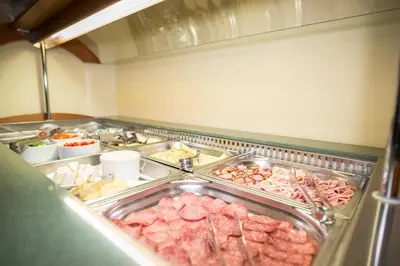 a buffet filled with lots of meat and other foods at Hotel City Bell in Prague