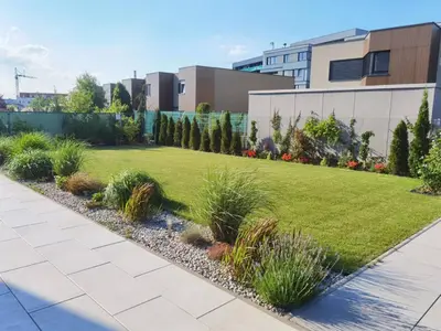 a garden with grass and plants in front of a building at yipin villa in Prague