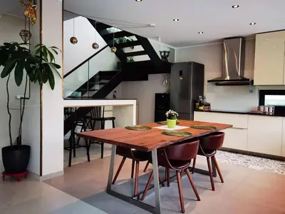 a kitchen and dining room with a wooden table and a staircase at yipin villa in Prague