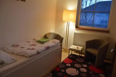 a bedroom with a bed and a chair and a window at Bohemica Apartman 3 in Kouřim