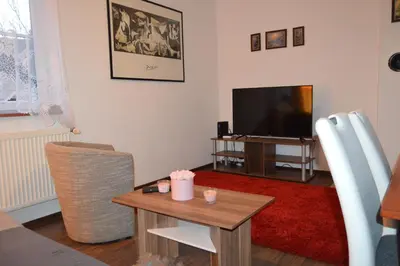 a living room with a table and a television at Bohemica Apartman 3 in Kouřim