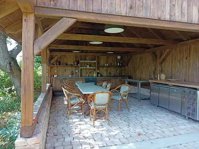 an outdoor kitchen with a table and chairs on a patio at Bohemica Apartman 3 in Kouřim