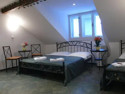 a bedroom with two beds and two windows at Pension Prague City in Prague