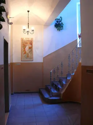 a hallway with a staircase in a building with a chandelier at Pension Prague City in Prague