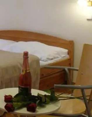 a bottle of beer and strawberries on a table in a bedroom at Pension Prague City in Prague
