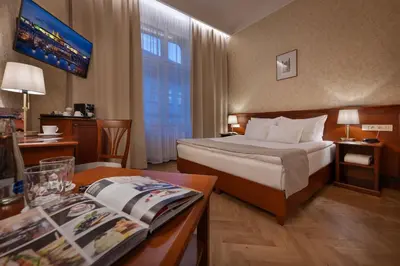 a hotel room with a bed and a table at Hotel Rott in Prague
