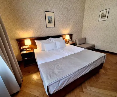 a hotel room with a large bed and two lamps at Hotel Rott in Prague