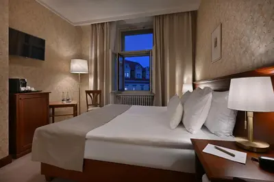 a hotel room with a large bed and a window at Hotel Rott in Prague