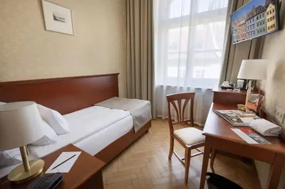 a hotel room with a large bed and a desk and a desk at Hotel Rott in Prague