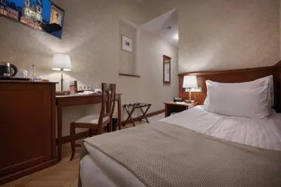 a hotel room with a bed and a desk at Hotel Rott in Prague