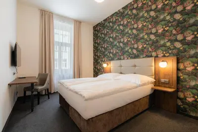 a bedroom with a bed and a floral wall at EA Hotel Victoria in Prague