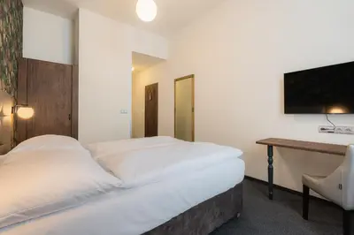 a hotel room with two beds and a desk at EA Hotel Victoria in Prague