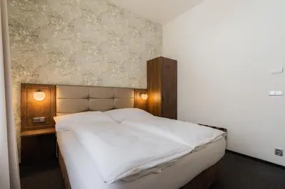 a bedroom with a large white bed with a wall at EA Hotel Victoria in Prague