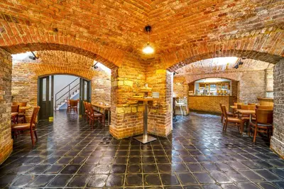 a restaurant with brick walls and tables and chairs at EA Hotel Victoria in Prague