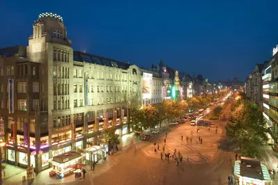 a busy city street at night with buildings and pedestrians at Prague Inn in Prague