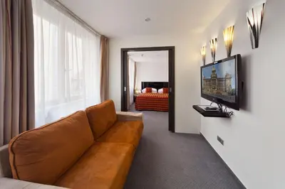 a living room with a brown couch and a television at Prague Inn in Prague