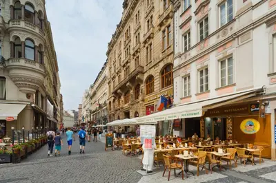 a city street with tables and chairs and buildings at Prague Inn in Prague