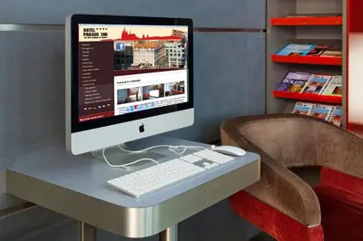 an apple computer sitting on a desk with a chair at Prague Inn in Prague