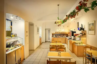 a large kitchen with tables and chairs in a room at Hotel Golden City Garni in Prague