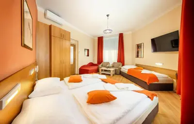 a hotel room with two beds and a living room at Hotel Golden City Garni in Prague