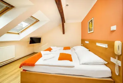 a bedroom with a large bed in a attic at Hotel Golden City Garni in Prague