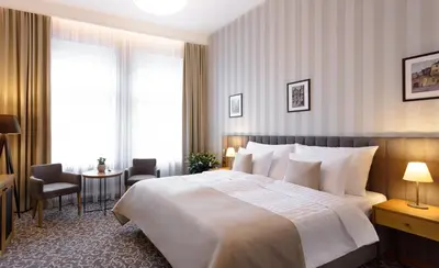 a hotel room with a large bed and a table at Hotel Schwaiger in Prague
