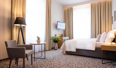 a hotel room with a bed and a desk and a chair at Hotel Schwaiger in Prague