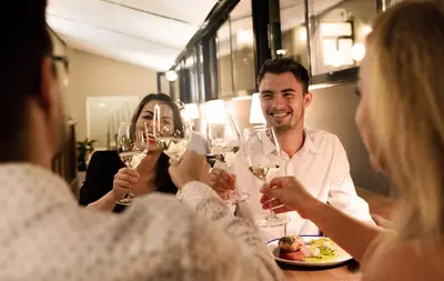 a group of people sitting around a table drinking wine at Hotel Schwaiger in Prague