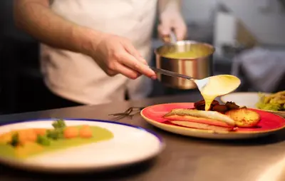 a person eating food on a table with a plate of food at Hotel Schwaiger in Prague