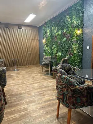 a waiting room with a large green wall at Gallery Hotel SIS in Prague